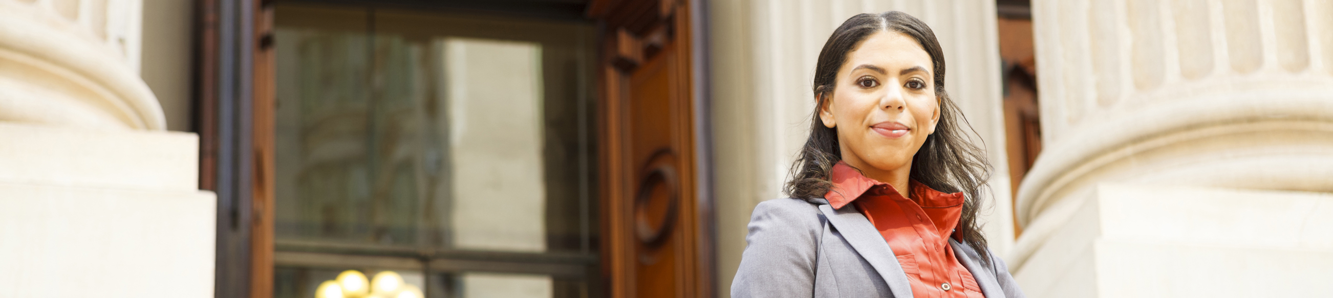 A woman standing in front of some stairs.