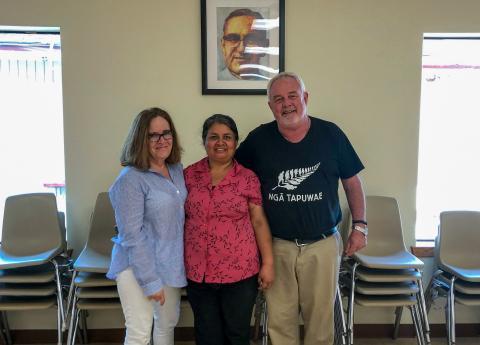 Executive director Anna Gallagher stands next to two people in a building.