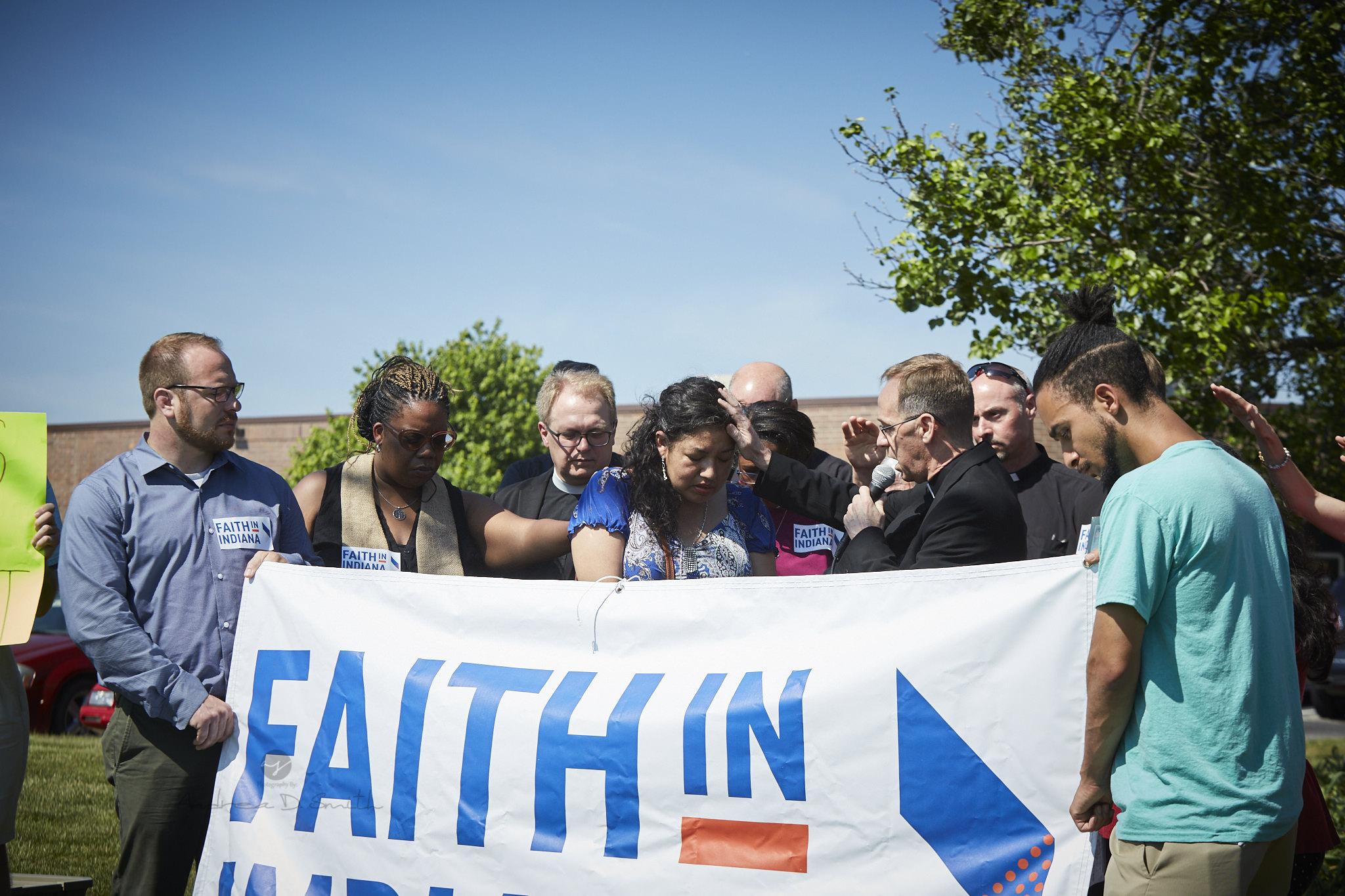 A group of people stand in front of a banner.