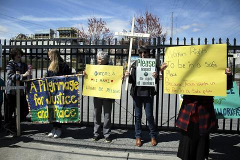 People hold signs on a pilgrimage. 