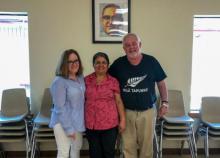 Executive director Anna Gallagher stands next to two people in a building.