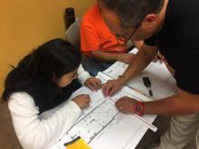 A man helps a young woman fill out information.