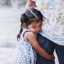 A girl hugging a person.