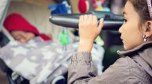 A girl pushes a stroller with a sleeping baby